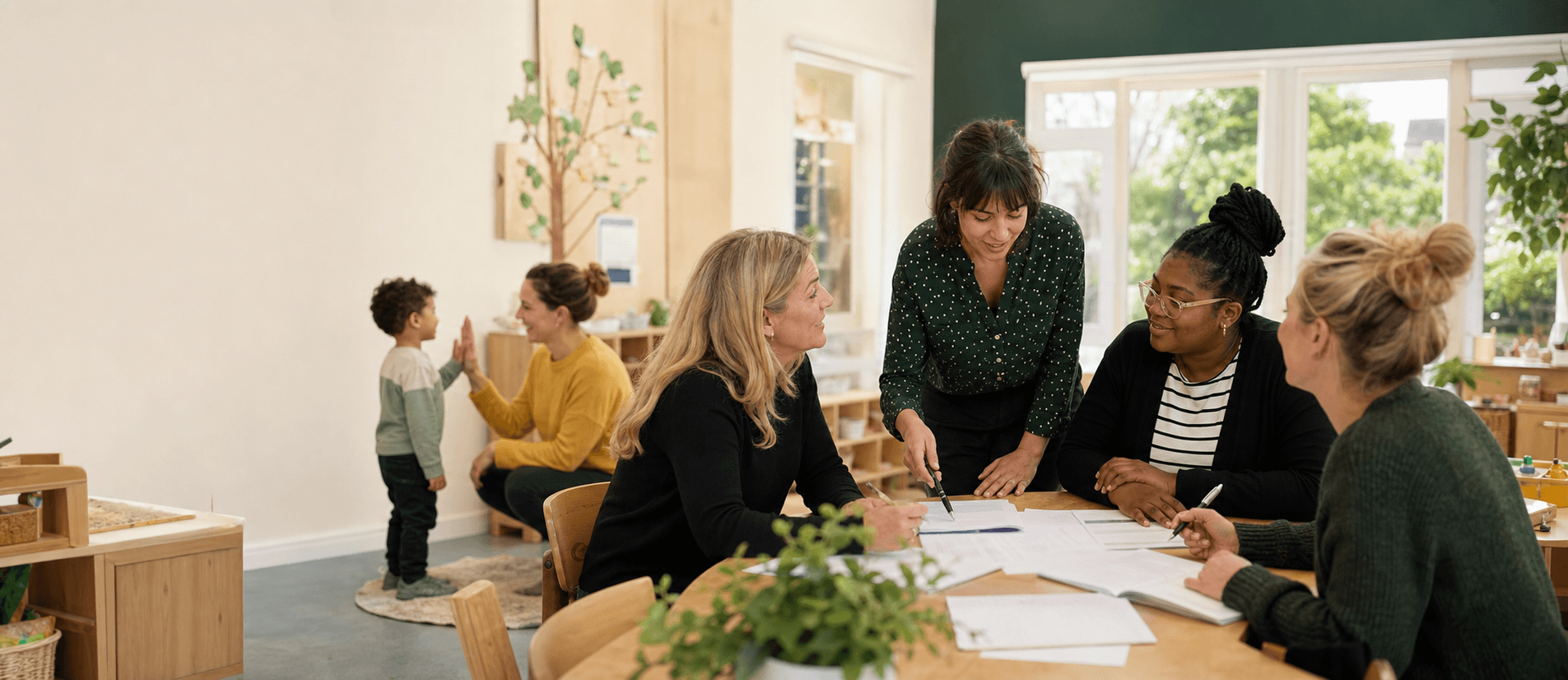 A nursery team collaborating while a practitioner welcomes a child