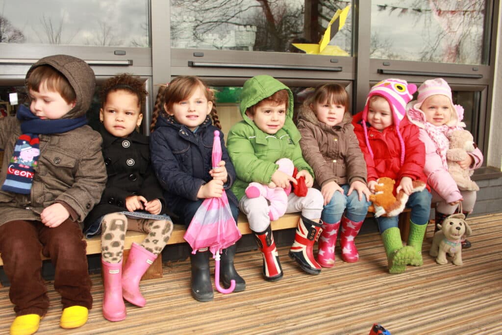 Squirrels children dressed in warm coats and wellington boots