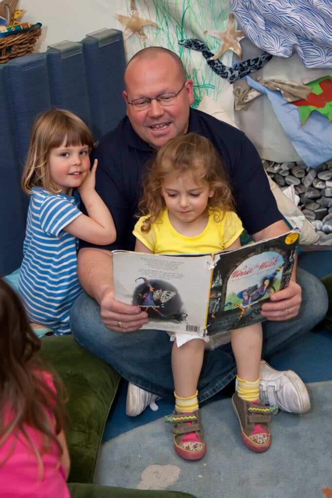 A parent reading a story with children at Squirrels
